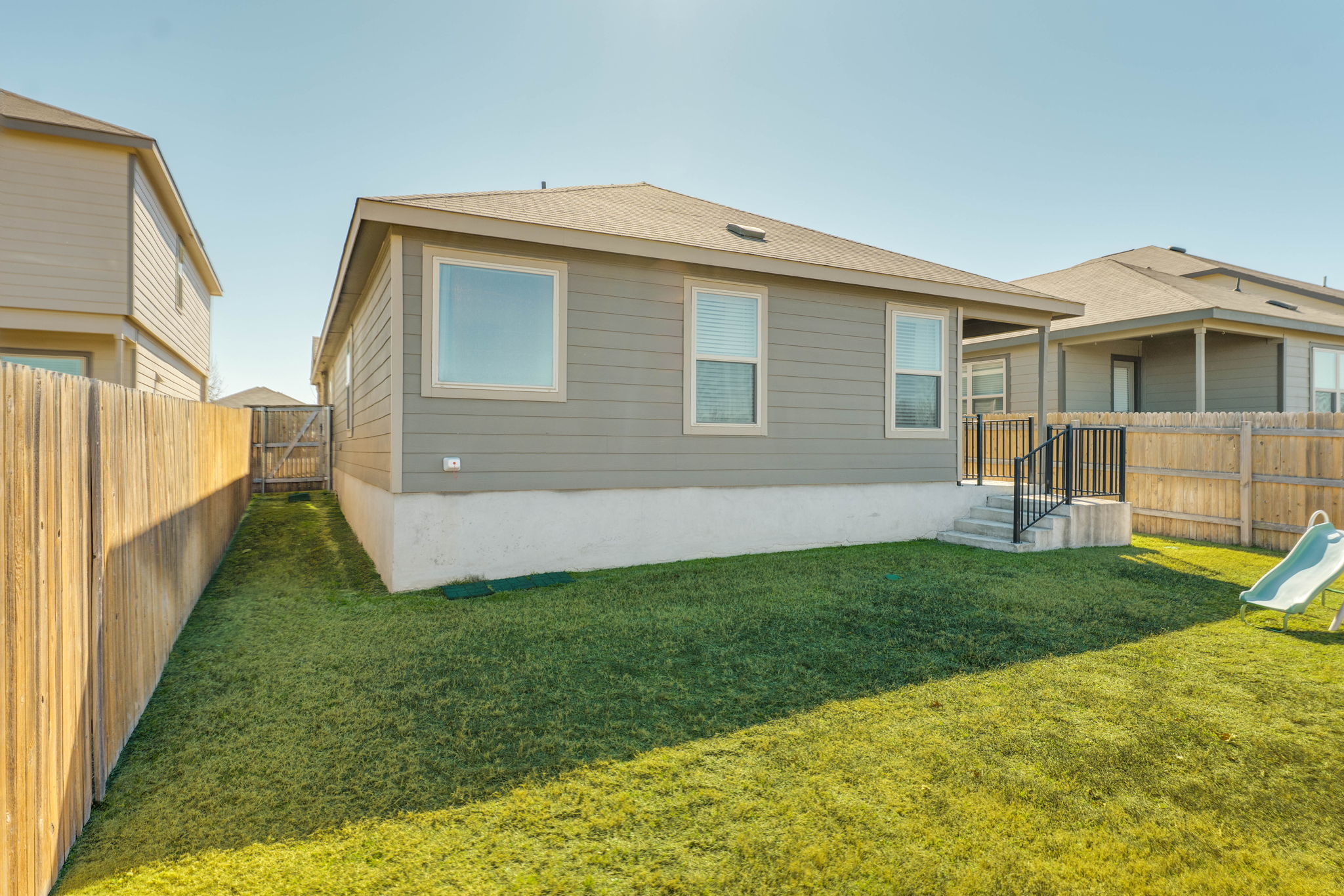 557 Greatest Gift Way Jarrell, TX 76537 - Photo 34 of 39 Rear view of property with a fenced backyard and a gate