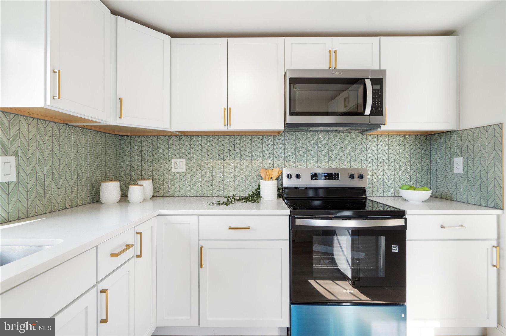 5425 Balistan Road Rosedale, MD 21237 - Photo 17 of 39 a kitchen with granite countertop a stove top oven microwave and cabinets