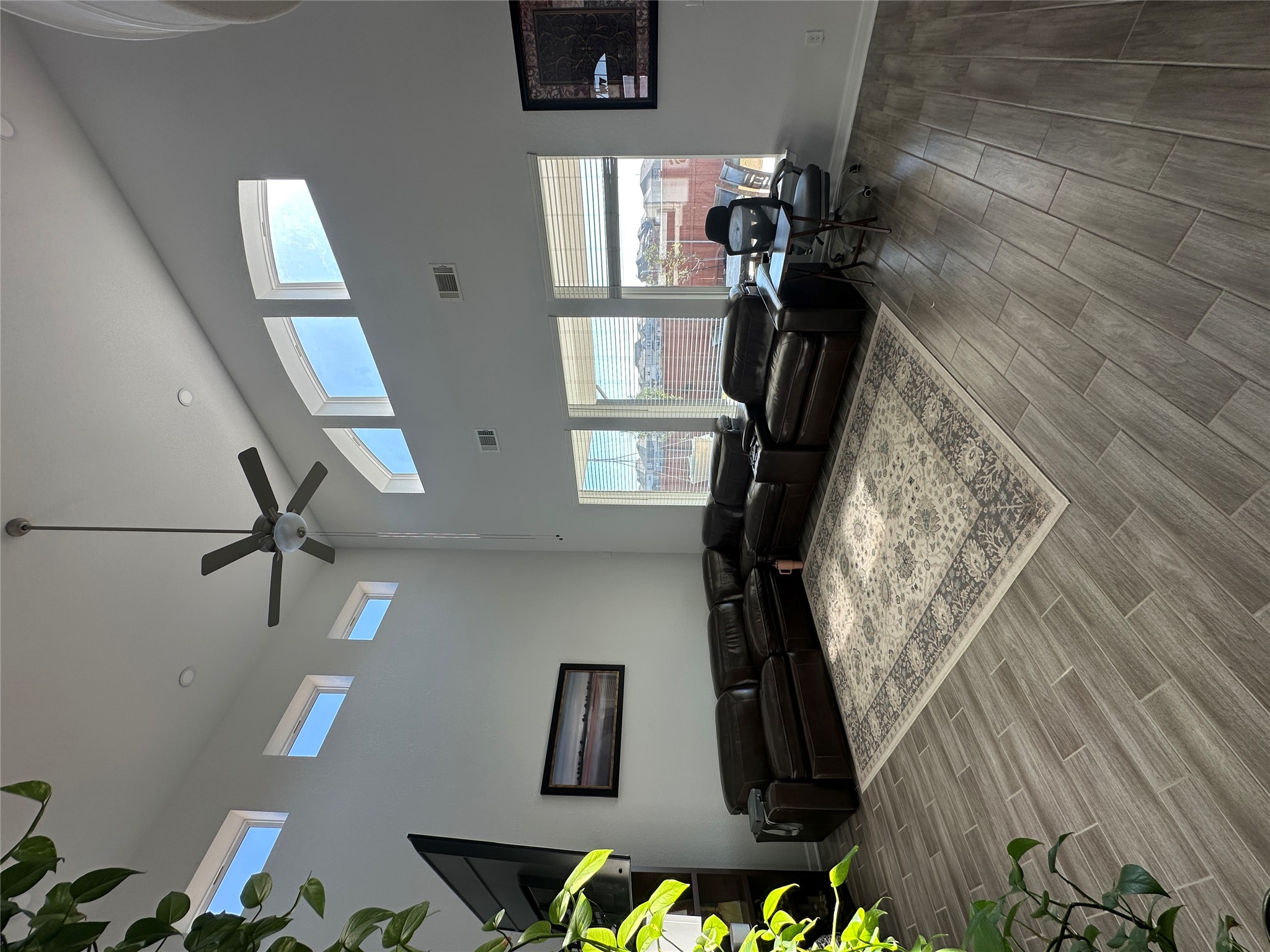 650 Wild Pecan Loop Buda, TX 78610 - Photo 9 of 28 Living room with wood finish floors, a ceiling fan, and a towering ceiling