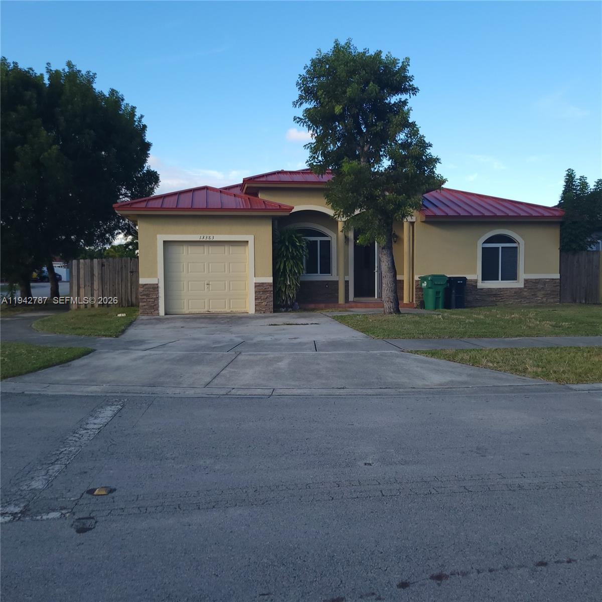 13383 Southwest 270th Street Homestead, FL 33032 - Photo 1 of 14 a front view of a house with a yard and garage