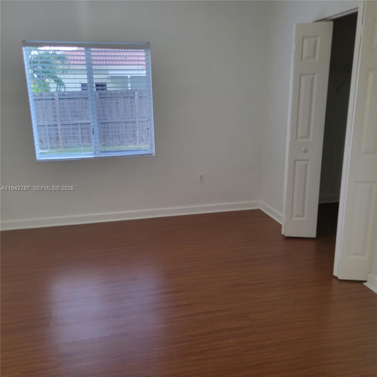 13383 Southwest 270th Street Homestead, FL 33032 - Photo 2 of 14 an empty room with wooden floor and windows