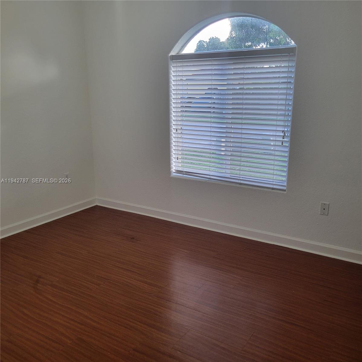 13383 Southwest 270th Street Homestead, FL 33032 - Photo 3 of 14 an empty room with wooden floor and windows