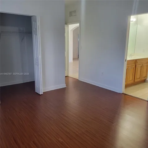 an empty room with wooden floor and closet