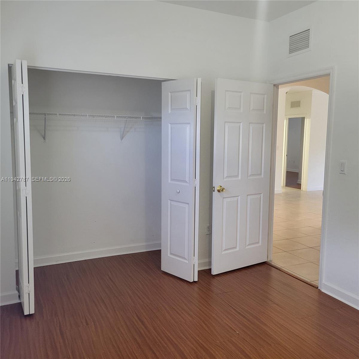 13383 Southwest 270th Street Homestead, FL 33032 - Photo 6 of 14 an empty room with wooden floor & closet area