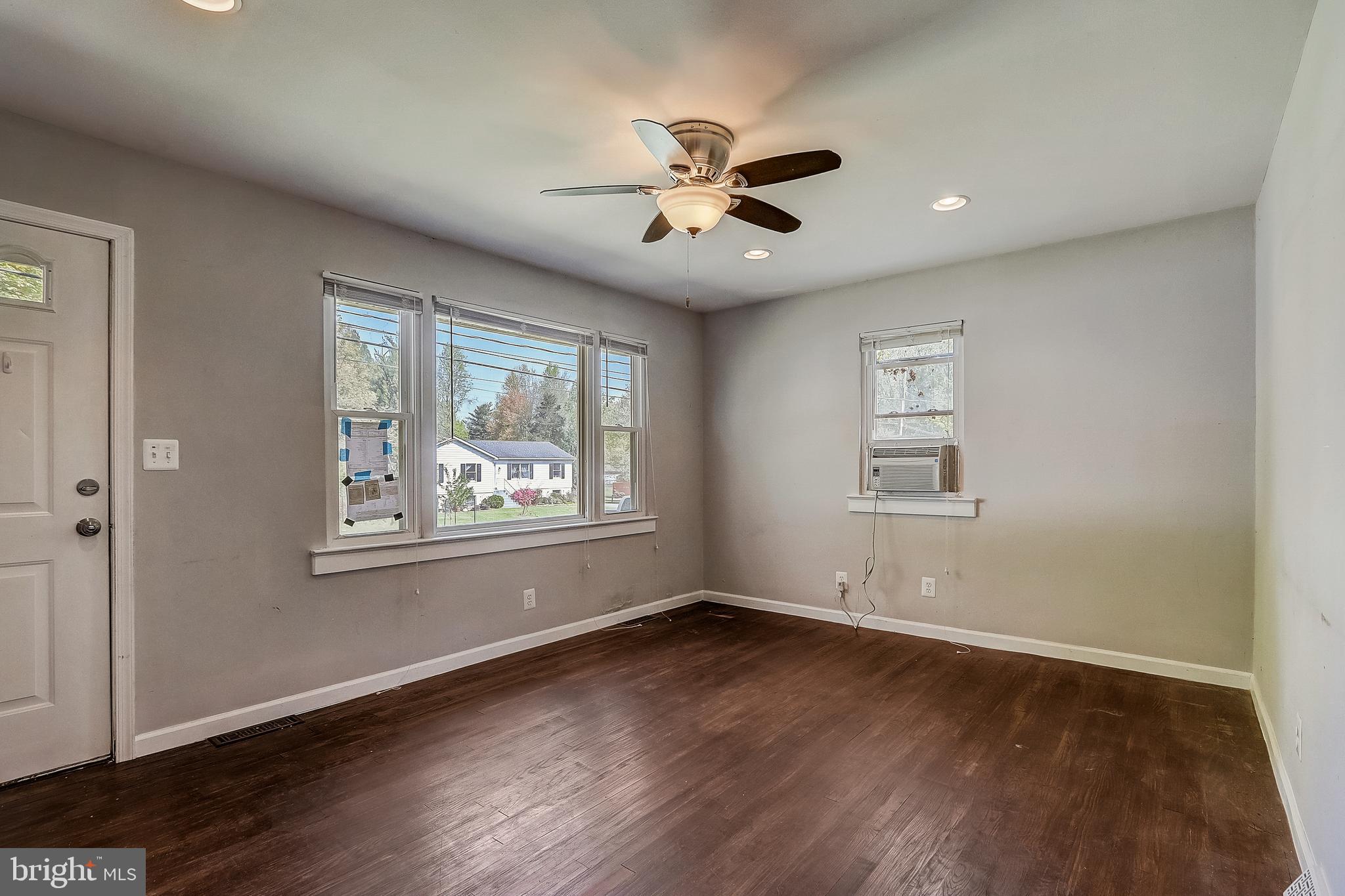 13221 Pine Road Bowie, MD 20720 - Photo 8 of 34 an empty room with wooden floor chandelier fan and windows
