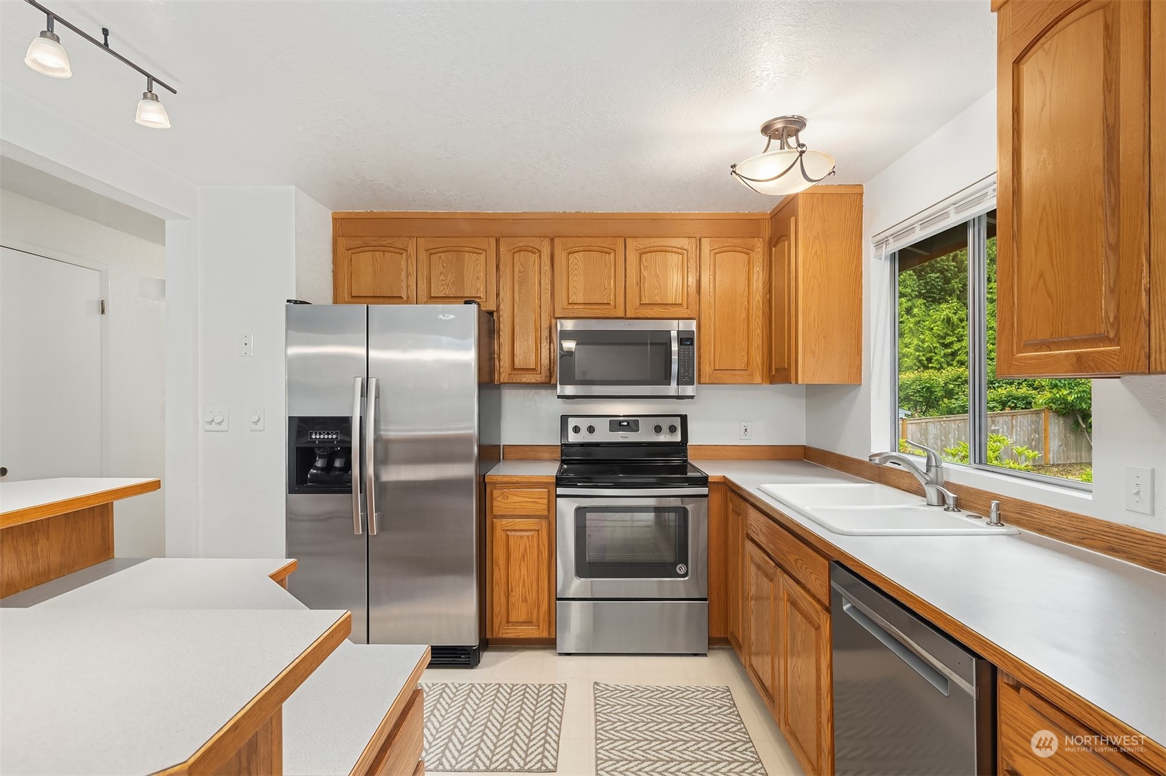 16604 3rd Avenue Southeast Bothell, WA 98012 - Photo 15 of 40 a kitchen with stainless steel appliances granite countertop a sink a stove a refrigerator with grey cabinets and wooden floor
