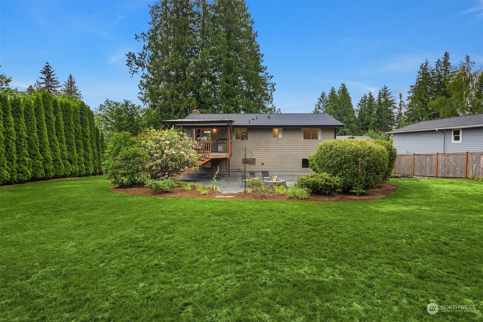 16604 3rd Avenue Southeast Bothell, WA 98012 - Photo 30 of 40 a backyard of a house with table and chairs plants and large tree