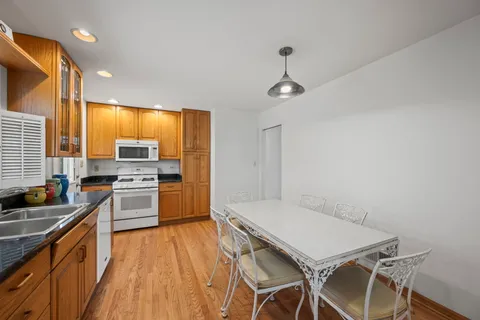 a kitchen with a table chairs stove and cabinets