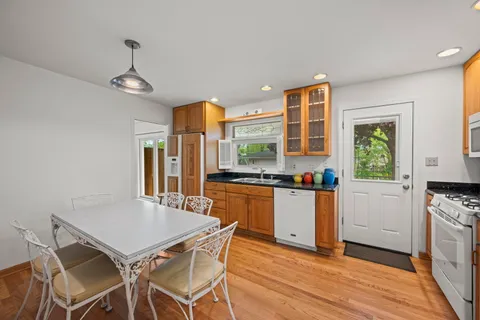 a kitchen with a table chairs refrigerator and cabinets