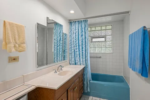 a bathroom with a tub sink and mirror
