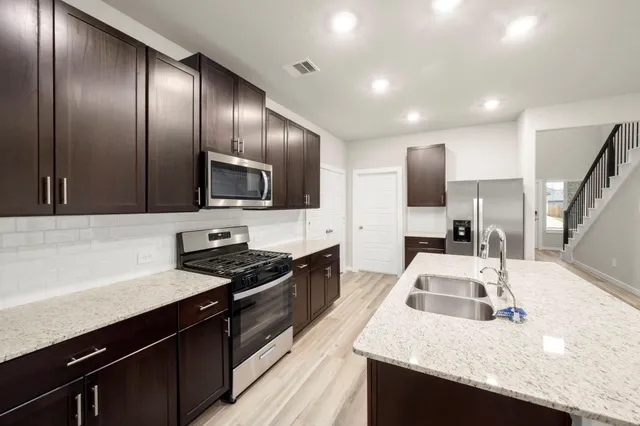 a kitchen with granite countertop stainless steel appliances and sink