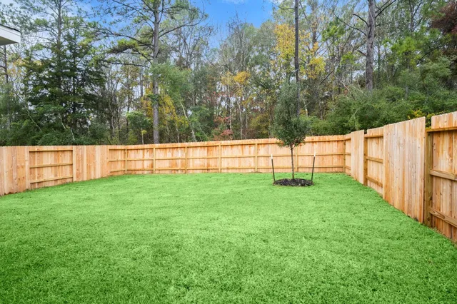 a view of yard with grass and wooden fence