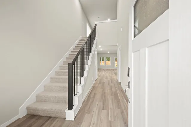 a view of a hallway with wooden floor and staircase