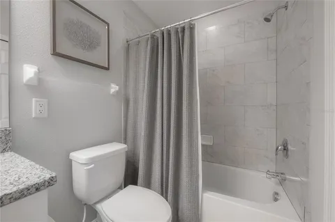 a white toilet sitting next to a bath tub