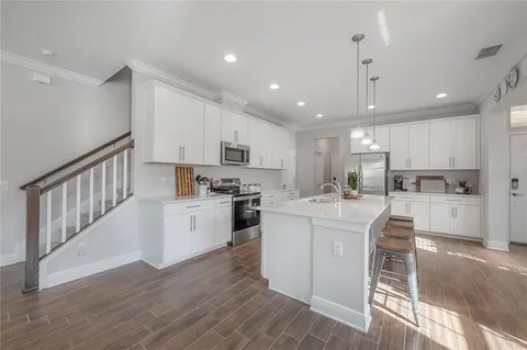 a kitchen with white cabinets and stainless steel appliances