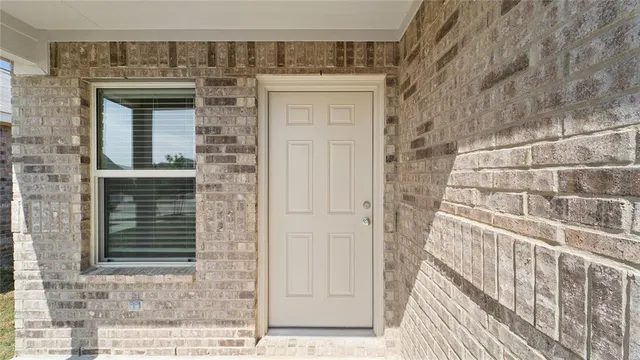 a view of a brick house with a door and wooden floor