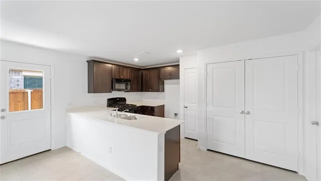 a kitchen that has a microwave a sink and a stove in it