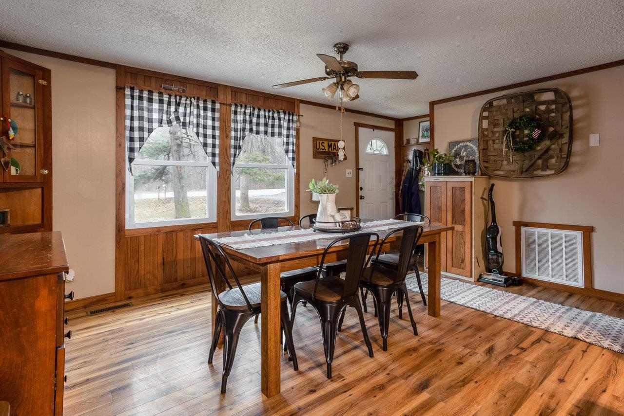 8448 Briery Branch Road Dayton, VA 22821 - Photo 5 of 37 a dining room with wooden floor a chandelier a wooden table and chairs