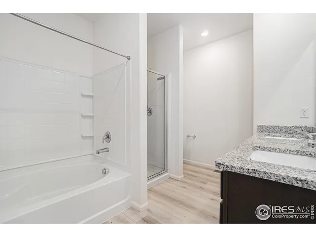 a bathroom with a granite countertop sink a mirror and a bathtub