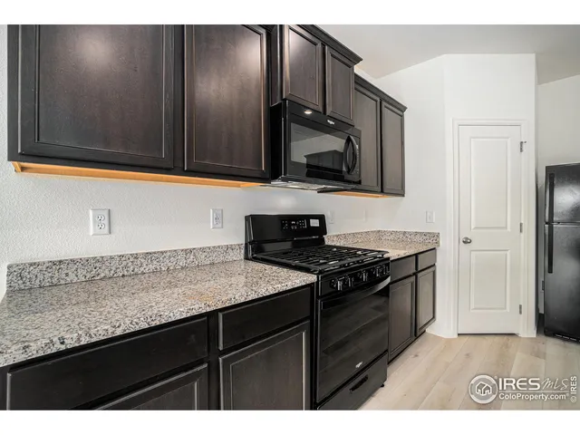 a kitchen with granite countertop stainless steel appliances a sink dishwasher and stove with wooden floor