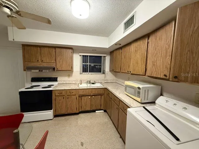 a kitchen with sink a microwave and cabinets