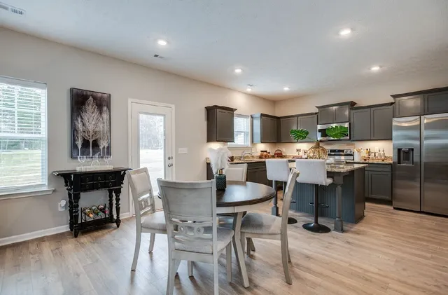 a kitchen with a table chairs refrigerator and cabinets