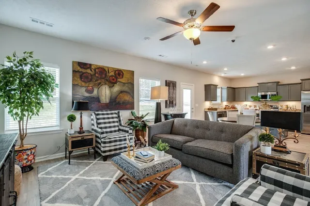 a living room with furniture kitchen view and a potted plant