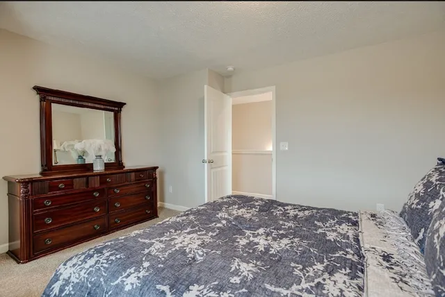 a bedroom with a bed and a mirror on dresser