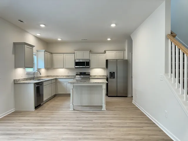 a kitchen with a refrigerator sink and cabinets