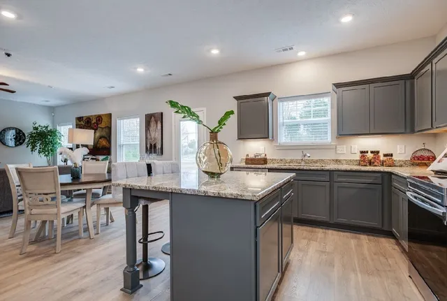 a kitchen with granite countertop sink stove and cabinets