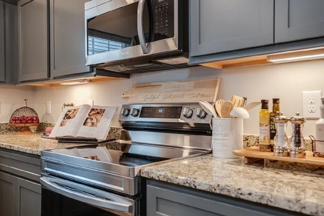 a kitchen with kitchen island granite countertop a stove and a microwave