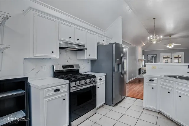 a kitchen with stainless steel appliances granite countertop a stove and a refrigerator