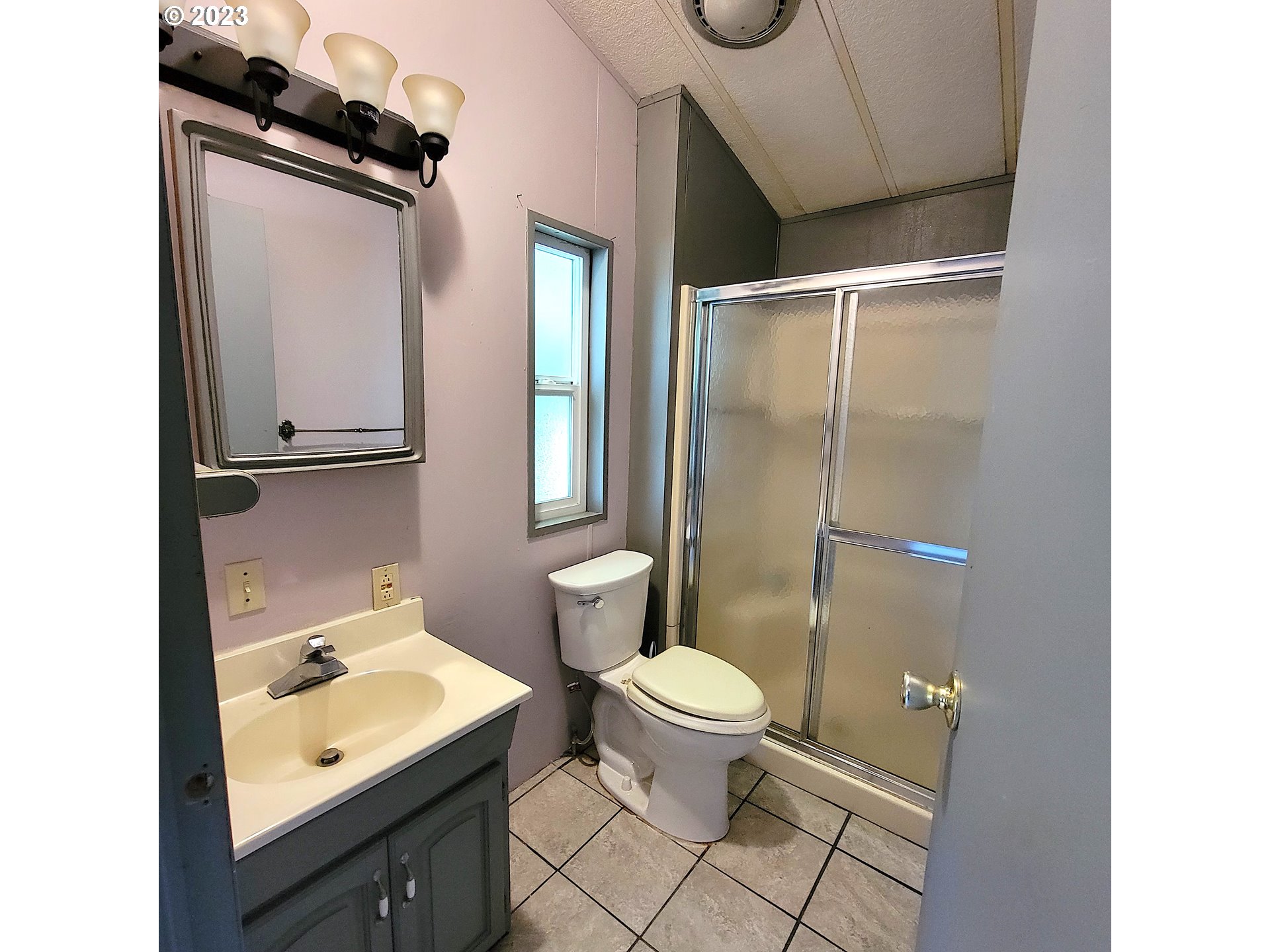 100 River Bend Road, Unit 6 Reedsport, OR 97467 - Photo 14 of 26 a bathroom with a sink a toilet a mirror and shower