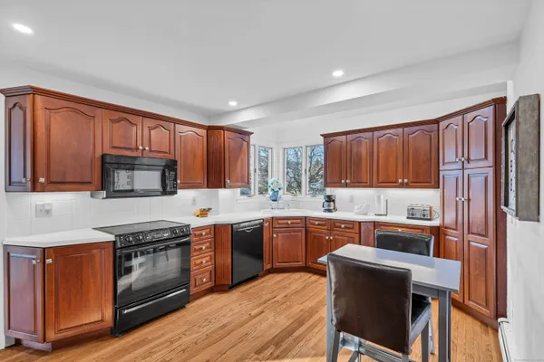 a view of kitchen with refrigerator and wooden floor