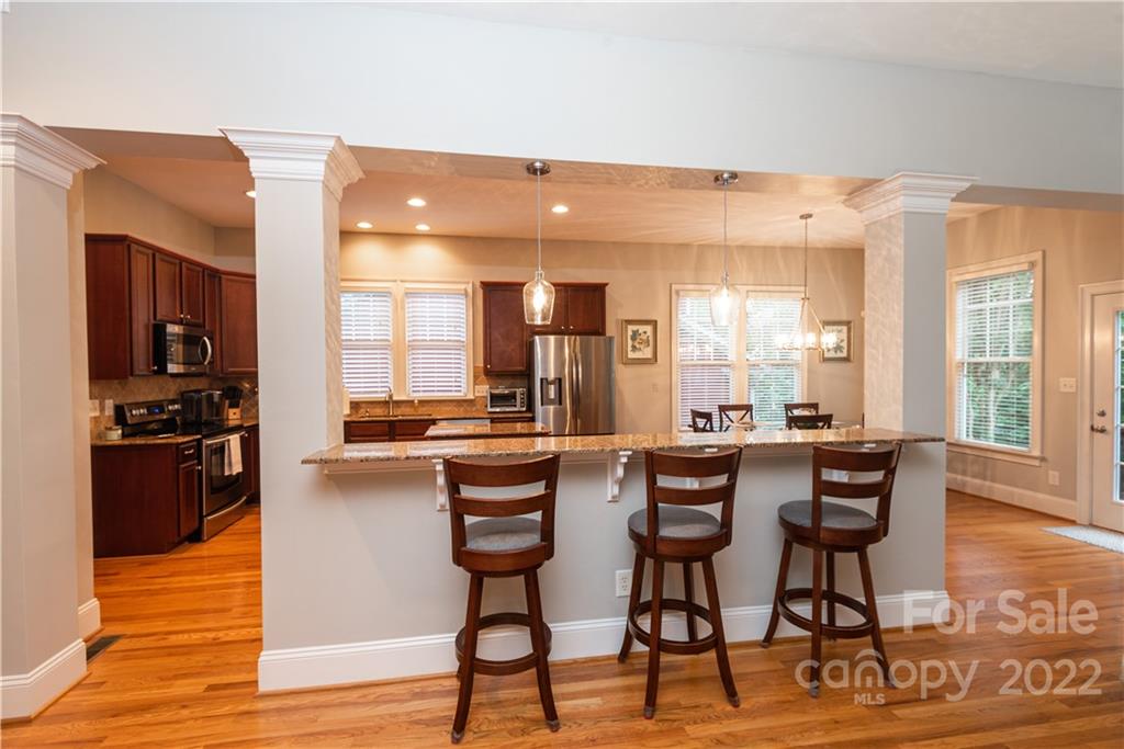 110 Mills Lane Fort Mill, SC 29708 - Photo 15 of 37 a kitchen with stainless steel appliances kitchen island granite countertop a table and chairs in it