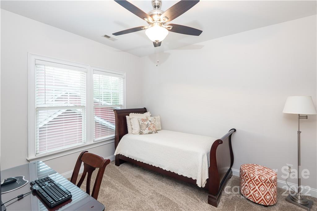 110 Mills Lane Fort Mill, SC 29708 - Photo 22 of 37 a bedroom with a bed and a chandelier