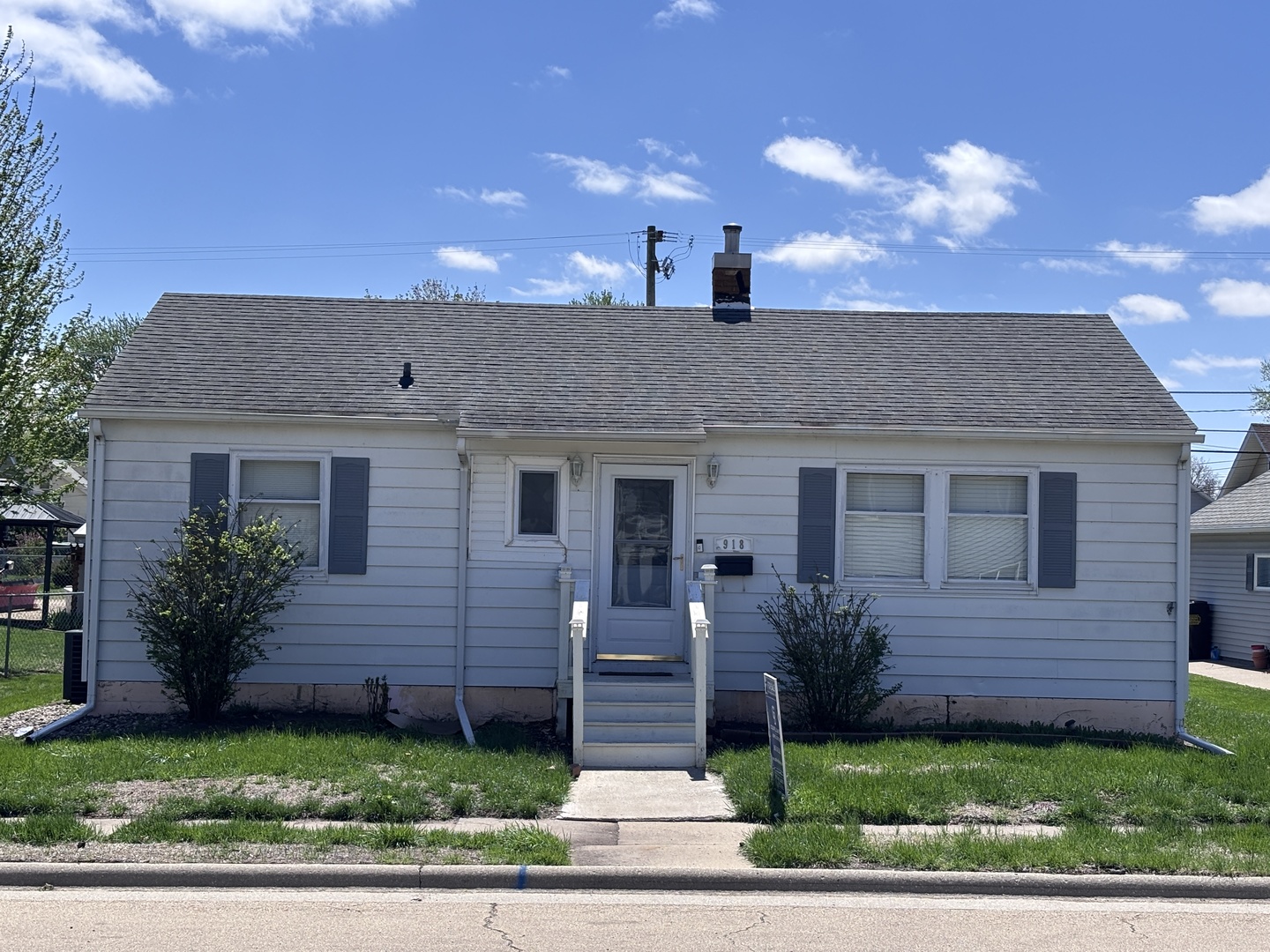 a front view of a house with a garden and plants
