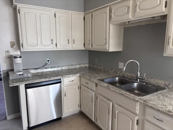 a kitchen with white cabinets and a sink