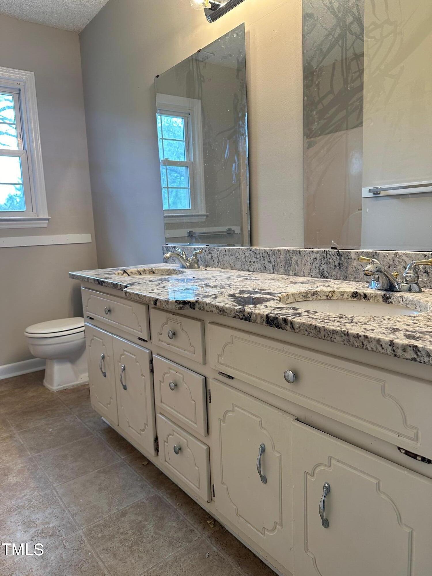 3309 Banks Road Raleigh, NC 27603 - Photo 8 of 11 a bathroom with a granite countertop toilet sink and mirror