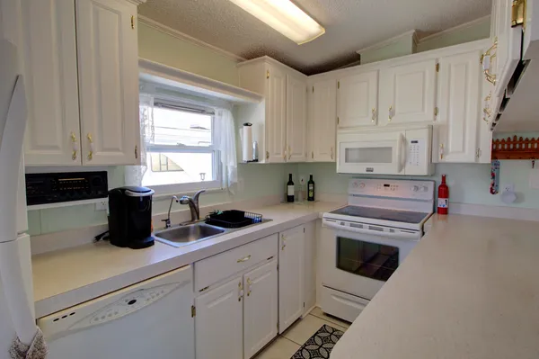 a kitchen with white cabinets and white appliances