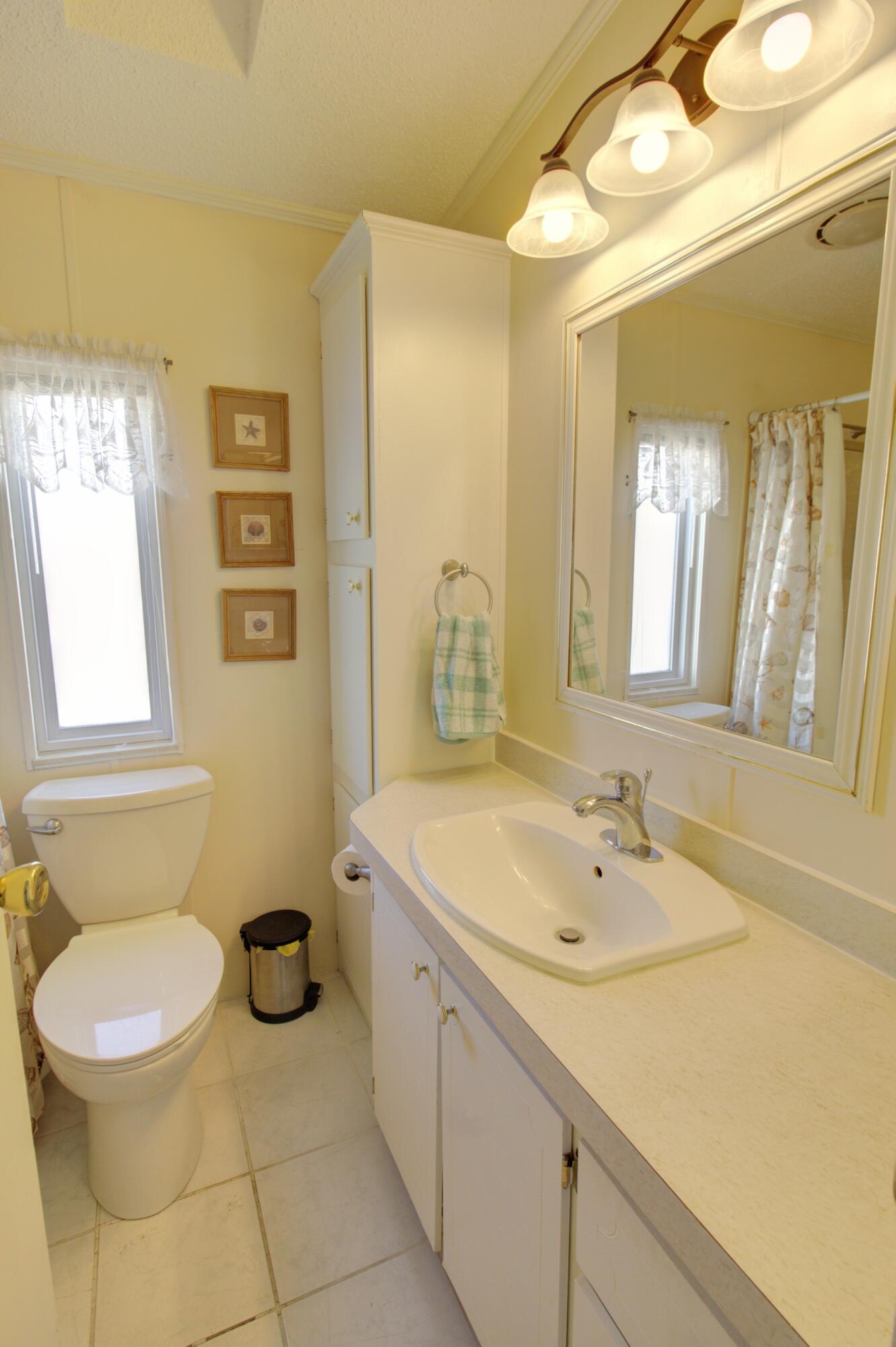 5395 Southeast 64th Terrace Okeechobee, FL 34974 - Photo 15 of 24 a bathroom with a sink a toilet and mirror