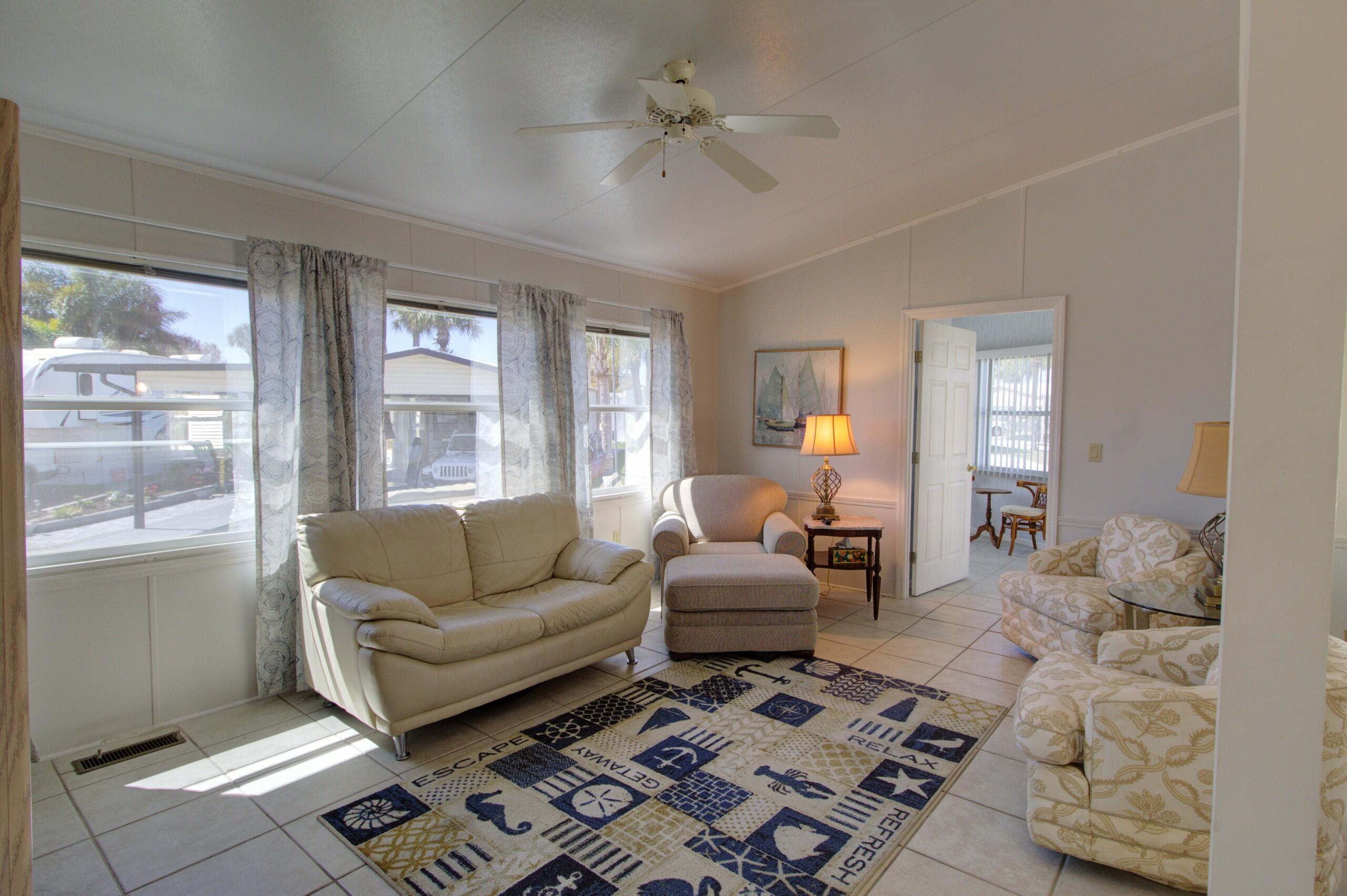 5395 Southeast 64th Terrace Okeechobee, FL 34974 - Photo 3 of 24 a living room with furniture a rug and a chandelier