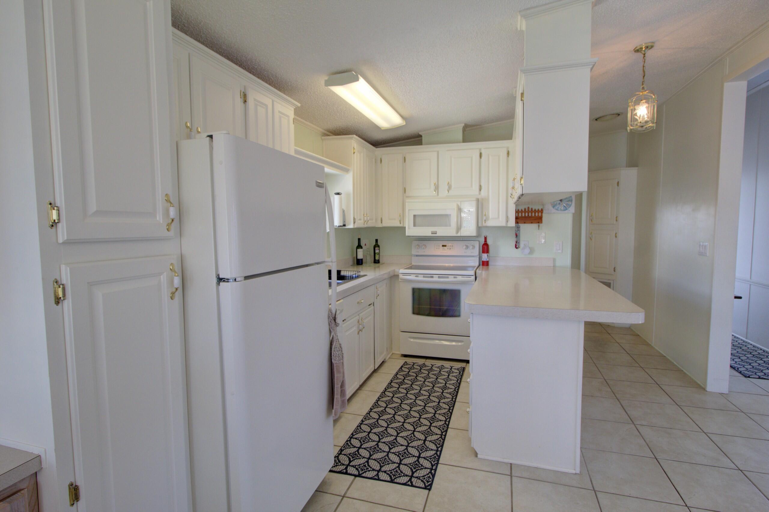 5395 Southeast 64th Terrace Okeechobee, FL 34974 - Photo 10 of 24 a kitchen with stainless steel appliances a refrigerator sink and cabinets