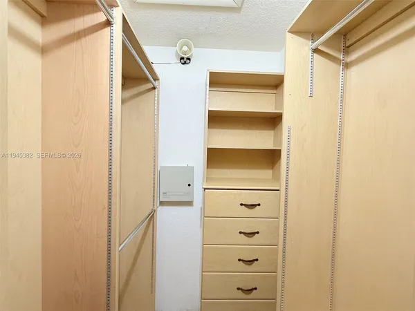 a view of walk in closet with empty racks