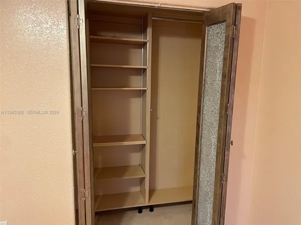 a view of walk in closet with empty racks