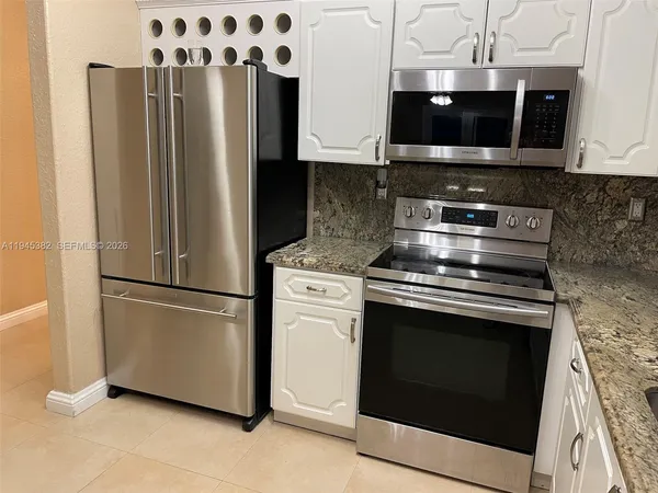 a view of a kitchen with stainless steel appliances and refrigerator