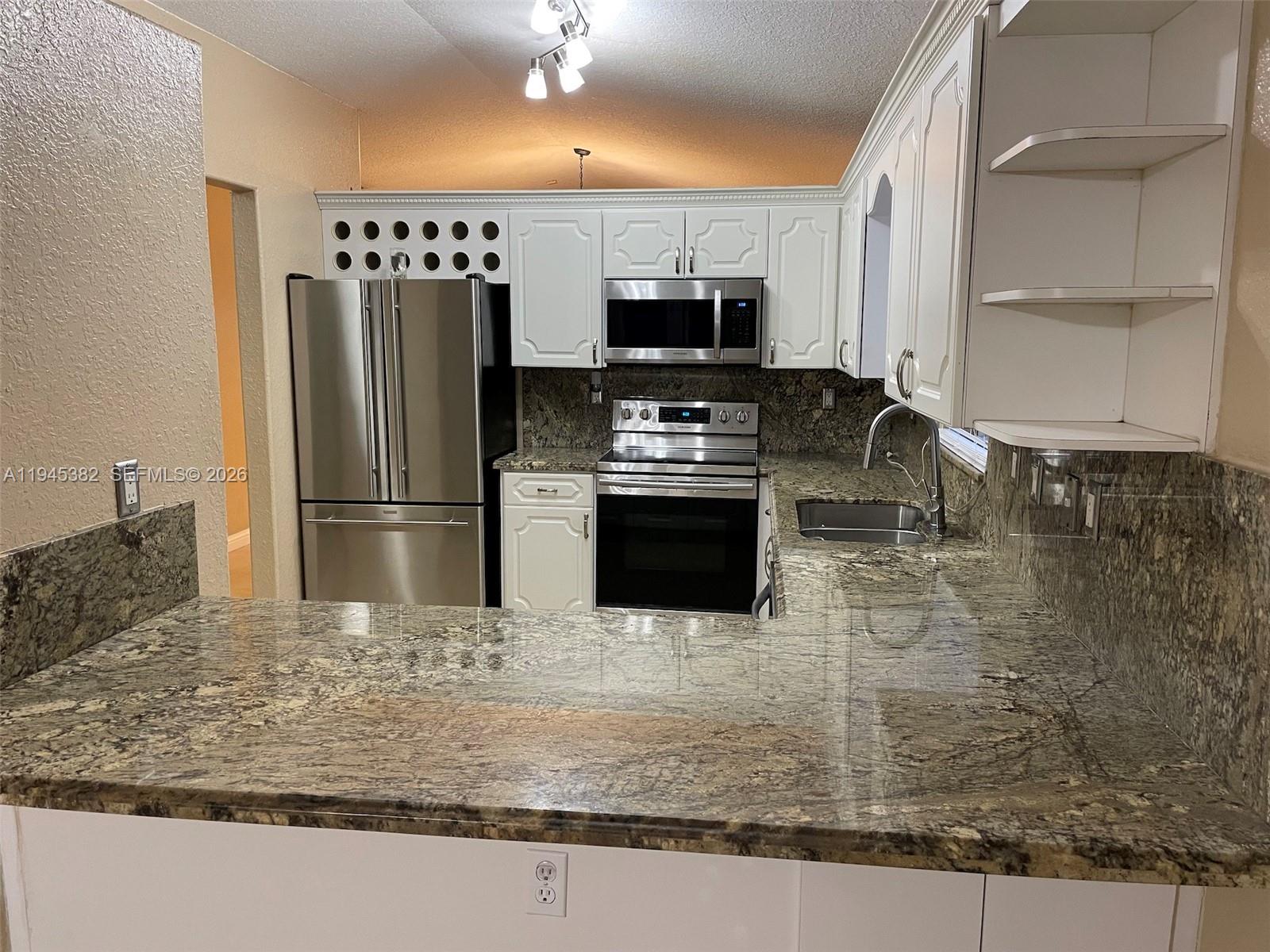 3559 West 74th Place Hialeah, FL 33018 - Photo 4 of 16 a kitchen with stainless steel appliances granite countertop a sink a stove and a refrigerator