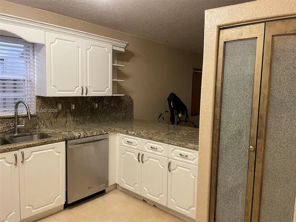 a kitchen with white cabinets and white appliances