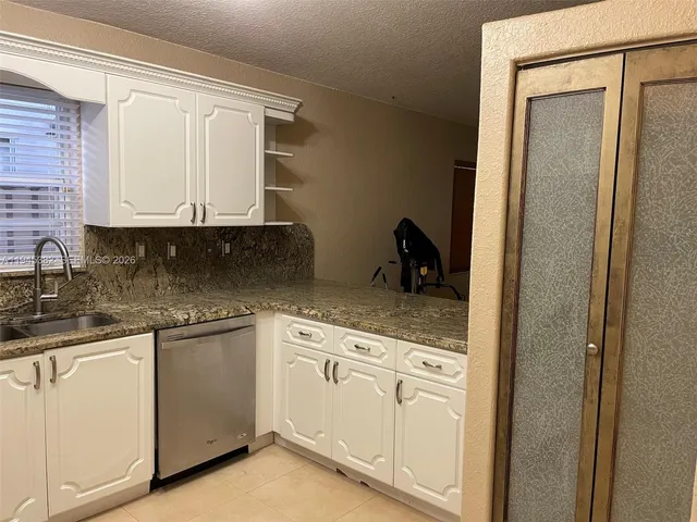 a kitchen with white cabinets and white appliances