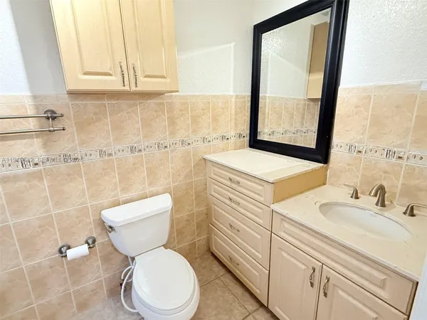 a bathroom with a sink vanity mirror and toilet